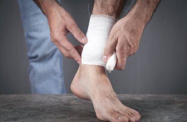 Yaralı ayağında bandaj olan bir adam..