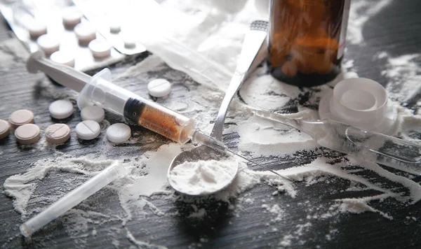 黑暗背景下的海洛因粉 药片和注射器 — 图库照片