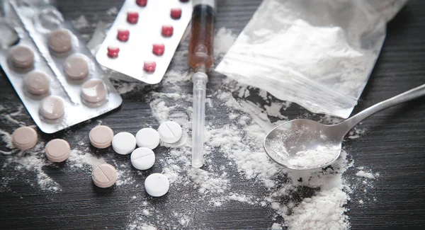 黒の背景にヘロインの粉 丸薬と注射器 — ストック写真
