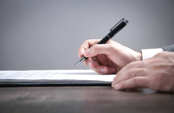 Бизнесмен подписывает договор в офисе.