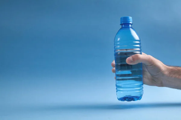 Male Hand Holding Bottle Water Blue Background — Stock Photo, Image