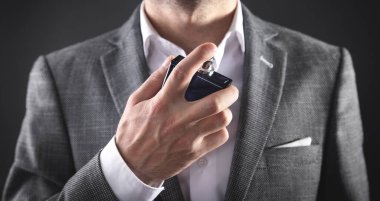 Beyaz, zarif bir adam parfüm sıkıyor..