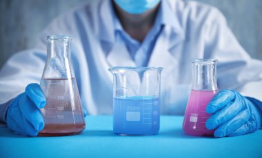 Laboratuvarda şişelerle çalışan bir kız..