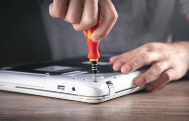 Adam dizüstü bilgisayarı tornavidayla söküyor..