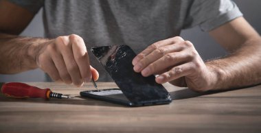 Teknisyen akıllı telefonu tamir ediyor. Onarım servisi