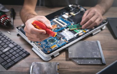 Bilgisayarı tornavidayla tamir eden teknisyen..