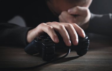 Elinde joystick tutan beyaz bir adam. Oyun bitti. Bağımlılık