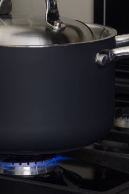 A black pan cooking on natural gas. Concept for gas crisis.