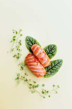 Minimum konsept. Suşi ruloları ve çubuklar, sarı arka planda izole edilmiş. Üst Manzara. Düz yatıyordu.