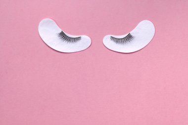 Pembe arka planda yaratıcı takma kirpikleri var. Güzellik pop sanat deseni. Parlak renkli arkaplan.