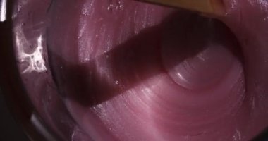 Karıştırmak için pembe balmumu hazırlığı. Tüy dökümü için yakın çekim cila.