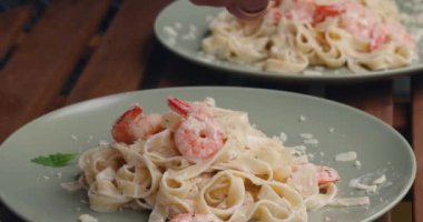 IItalian shrimp pasta with arugula. talian shrimp pasta topped with arugula.