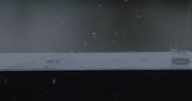 Heavy rain slow motion close up shot. Droplet of water and splash, drop of water falling to floor, beautiful surface texture of liquid nature.