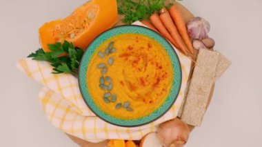 Beyaz zemin üzerinde balkabağı kremalı çorba, çorba yapmak için sebze, yavaş dönüş kompozisyonu, üst görünüm