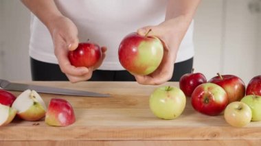 Kızın elleri elmaları gösteriyor ve bir tanesi iki parçaya ayırıyor.