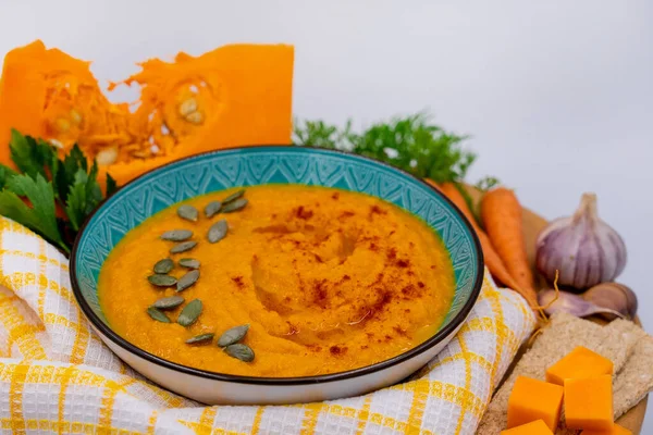 Beyaz arka planda balkabağı kremalı çorba, çorba yapmak için sebze, yan görüş.