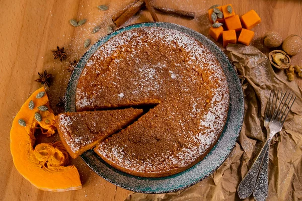 Tahtada balkabağı turtası ve yemek malzemeleri, üst manzara.