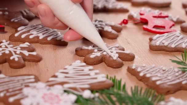 Zeichnung Mit Weißem Zuckerguss Auf Weihnachtsplätzchen Tisch Mit Neujahrsdekoration Dekoriert — Stockvideo