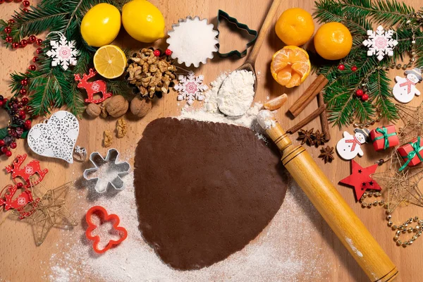 Noel arkaplanında Noel kurabiyesi yapmak için hamur ve merdane, üst manzara