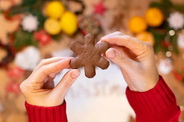 Noel arkaplanındaki bir kızın ellerinde kar taneleri şeklinde zencefilli çörekler, yakın plan, üst manzara
