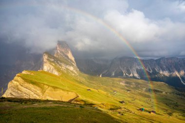 Dolomitlerdeki Seceda zirvesinin üstündeki gökkuşağının görüntüsü.