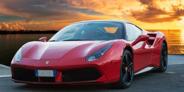 Kırmızı araba modeli Ferrari 488 GTB 'nin hızlı ve lüks tasarımı altın gün batımlı fantastik bir arka planda yer almaktadır. Ferrari 488, İtalya 'nın başkenti Roma' da 2015 yılından bu yana üretilen spor otomobildir.