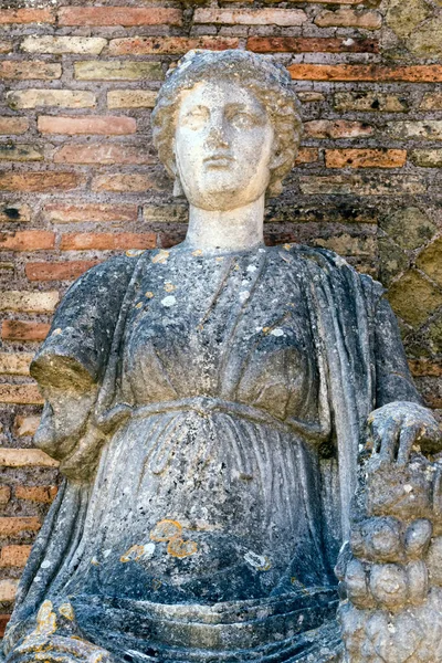 Portrait of Fortuna Annonaria statue, a Roman Goddess located at the domus of Fortuna Annonaria situated in ancent Roman village ruins of Ostia Antica with well preserved buildings  and art objects of ancient Rome, Italy