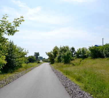 Renkli arka planda, kırsal alanda güzel boş asfalt yol. Fotoğrafçılık, kırsal kesimden geçen yeni boş asfalt yolu içeriyor. Yeşillik kırsalında hız aracı için boş asfalt yol