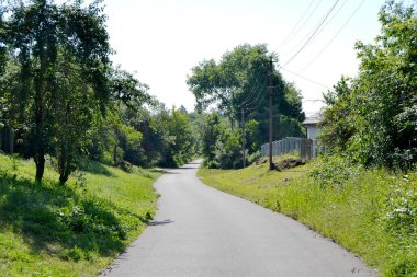 Renkli arka planda, kırsal alanda güzel boş asfalt yol. Fotoğrafçılık, kırsal kesimden geçen yeni boş asfalt yolu içeriyor. Yeşillik kırsalında hız aracı için boş asfalt yol