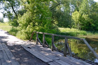 Renkli arka planda nehrin üzerinde güzel duran ahşap bir köprü. Fotoğraf, nehrin yukarısındaki eski ahşap köprüden oluşuyor. Doğal park için nehirdeki eski ahşap köprü..