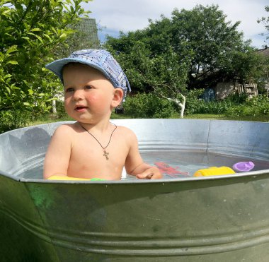 Renkli fotoğraf için poz veren çocuk yüzlü güzel bir oğlan. Cadre, çocuk görünümlü bir erkek bebekten, beyaz bir yüz ifadesinden oluşuyor. Sağlıklı erkek bebek, çocuk yüzü. İyi bir atış için rahatlıyor..
