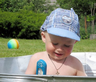 Renkli fotoğraf için poz veren çocuk yüzlü güzel bir oğlan. Cadre, çocuk görünümlü bir erkek bebekten, beyaz bir yüz ifadesinden oluşuyor. Sağlıklı erkek bebek, çocuk yüzü. İyi bir atış için rahatlıyor..
