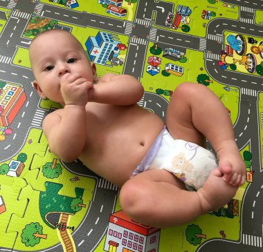 Renkli fotoğraf için poz veren çocuk yüzlü güzel bir oğlan. Cadre, çocuk görünümlü bir erkek bebekten, beyaz bir yüz ifadesinden oluşuyor. Sağlıklı erkek bebek, çocuk yüzü. İyi bir atış için rahatlıyor..