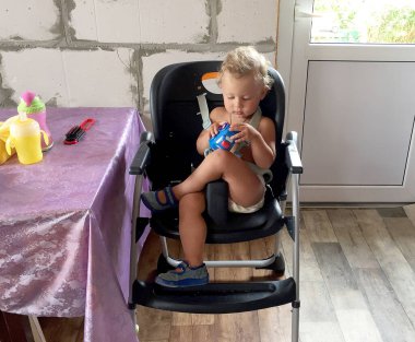 Renkli fotoğraf için poz veren çocuk yüzlü güzel bir oğlan. Cadre, çocuk görünümlü bir erkek bebekten, beyaz bir yüz ifadesinden oluşuyor. Sağlıklı erkek bebek, çocuk yüzü. İyi bir atış için rahatlıyor..