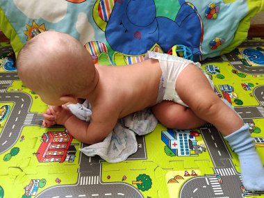 Renkli fotoğraf için poz veren çocuk yüzlü güzel bir oğlan. Cadre, çocuk görünümlü bir erkek bebekten, beyaz bir yüz ifadesinden oluşuyor. Sağlıklı erkek bebek, çocuk yüzü. İyi bir atış için rahatlıyor..