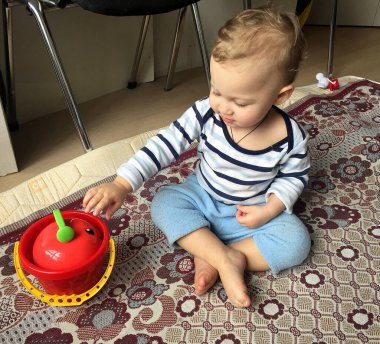 Renkli fotoğraf için poz veren çocuk yüzlü güzel bir oğlan. Cadre, çocuk görünümlü bir erkek bebekten, beyaz bir yüz ifadesinden oluşuyor. Sağlıklı erkek bebek, çocuk yüzü. İyi bir atış için rahatlıyor..