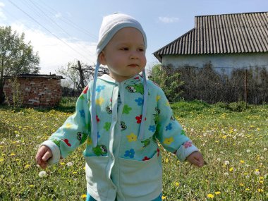 Renkli fotoğraf için poz veren çocuk yüzlü güzel bir oğlan. Cadre, çocuk görünümlü bir erkek bebekten, beyaz bir yüz ifadesinden oluşuyor. Sağlıklı erkek bebek, çocuk yüzü. İyi bir atış için rahatlıyor..