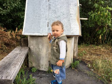 Renkli fotoğraf için poz veren çocuk yüzlü güzel bir oğlan. Cadre, çocuk görünümlü bir erkek bebekten, beyaz bir yüz ifadesinden oluşuyor. Sağlıklı erkek bebek, çocuk yüzü. İyi bir atış için rahatlıyor..