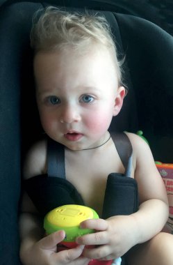 Renkli fotoğraf için poz veren çocuk yüzlü güzel bir oğlan. Cadre, çocuk görünümlü bir erkek bebekten, beyaz bir yüz ifadesinden oluşuyor. Sağlıklı erkek bebek, çocuk yüzü. İyi bir atış için rahatlıyor..