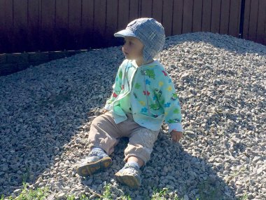 Renkli fotoğraf için poz veren çocuk yüzlü güzel bir oğlan. Cadre, çocuk görünümlü bir erkek bebekten, beyaz bir yüz ifadesinden oluşuyor. Sağlıklı erkek bebek, çocuk yüzü. İyi bir atış için rahatlıyor..