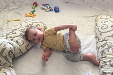 Renkli fotoğraf için poz veren çocuk yüzlü güzel bir oğlan. Cadre, çocuk görünümlü bir erkek bebekten, beyaz bir yüz ifadesinden oluşuyor. Sağlıklı erkek bebek, çocuk yüzü. İyi bir atış için rahatlıyor..