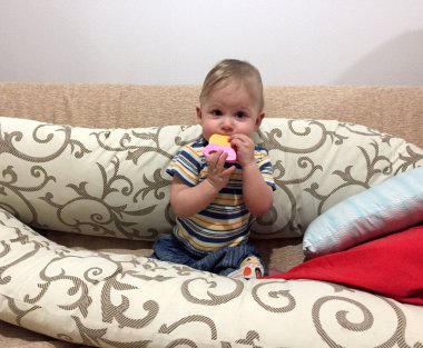 Renkli fotoğraf için poz veren çocuk yüzlü güzel bir oğlan. Cadre, çocuk görünümlü bir erkek bebekten, beyaz bir yüz ifadesinden oluşuyor. Sağlıklı erkek bebek, çocuk yüzü. İyi bir atış için rahatlıyor..