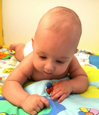 Renkli fotoğraf için poz veren çocuk yüzlü güzel bir oğlan. Cadre, çocuk görünümlü bir erkek bebekten, beyaz bir yüz ifadesinden oluşuyor. Sağlıklı erkek bebek, çocuk yüzü. İyi bir atış için rahatlıyor..