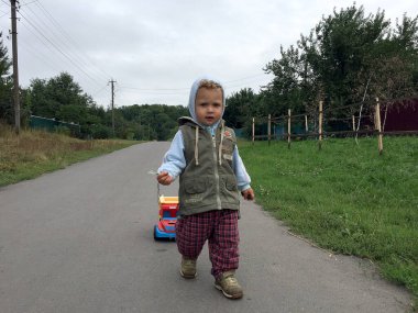 Renkli fotoğraf için poz veren çocuk yüzlü güzel bir oğlan. Cadre, çocuk görünümlü bir erkek bebekten, beyaz bir yüz ifadesinden oluşuyor. Sağlıklı erkek bebek, çocuk yüzü. İyi bir atış için rahatlıyor..