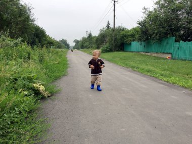 Renkli fotoğraf için poz veren çocuk yüzlü güzel bir oğlan. Cadre, çocuk görünümlü bir erkek bebekten, beyaz bir yüz ifadesinden oluşuyor. Sağlıklı erkek bebek, çocuk yüzü. İyi bir atış için rahatlıyor..