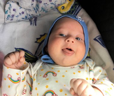 Renkli fotoğraf için poz veren çocuk yüzlü güzel bir oğlan. Cadre, çocuk görünümlü bir erkek bebekten, beyaz bir yüz ifadesinden oluşuyor. Sağlıklı erkek bebek, çocuk yüzü. İyi bir atış için rahatlıyor..