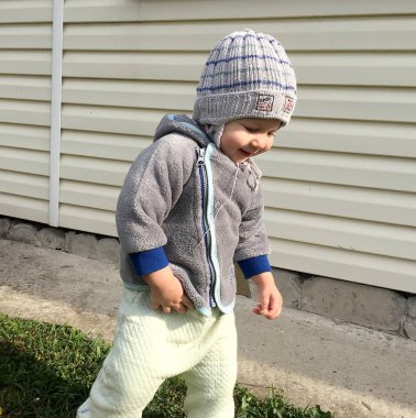 Renkli fotoğraf için poz veren çocuk yüzlü güzel bir oğlan. Cadre, çocuk görünümlü bir erkek bebekten, beyaz bir yüz ifadesinden oluşuyor. Sağlıklı erkek bebek, çocuk yüzü. İyi bir atış için rahatlıyor..