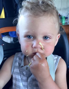 Renkli fotoğraf için poz veren çocuk yüzlü güzel bir oğlan. Cadre, çocuk görünümlü bir erkek bebekten, beyaz bir yüz ifadesinden oluşuyor. Sağlıklı erkek bebek, çocuk yüzü. İyi bir atış için rahatlıyor..