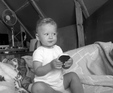 Renkli fotoğraf için poz veren çocuk yüzlü güzel erkek bebek, çocuk imajı olan erkek bebek kadrosu, beyaz yüz ifadesi, çocuk suratlı sağlıklı bir erkek çocuğu, iyi bir çekim için dinleniyor.