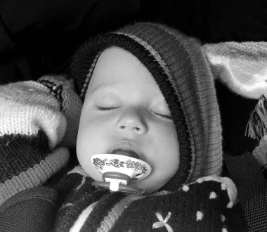 Renkli fotoğraf için fotoğrafçı pozu veren uyuyan erkek bebek, uyuyan bebek emziği, gülümseyen yüz, çocuk emziğindeki sağlıklı uyuyan erkek çocuğu.